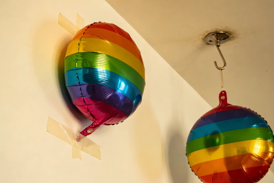 Air-filled balloons attached to ceiling using hooks and tape