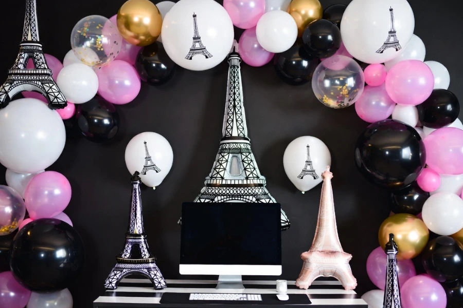 Paris theme party decorations with Eiffel Tower balloons and coordinated black and pink table décor
