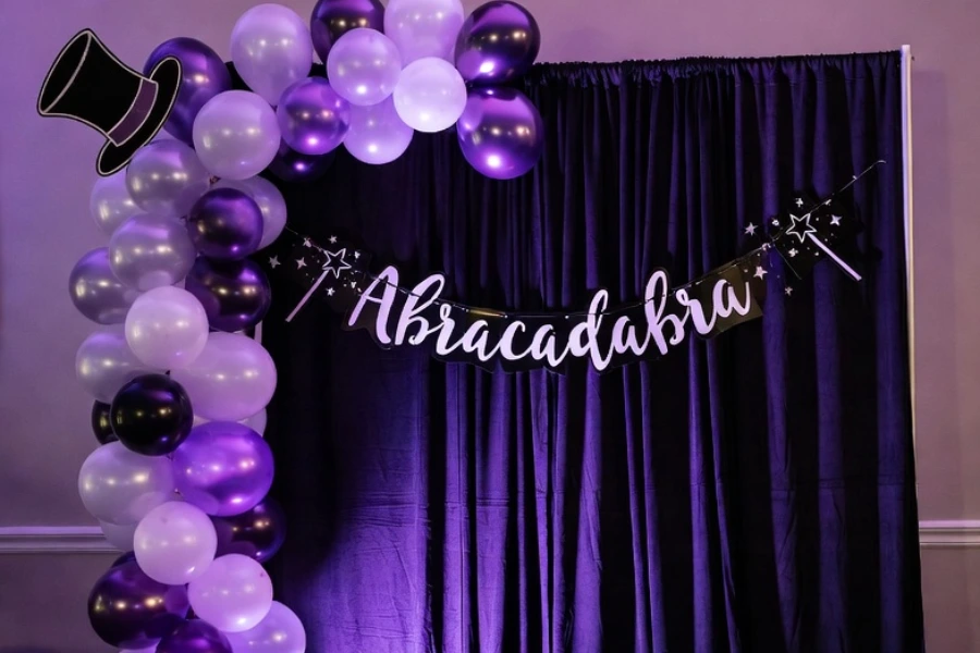 magic themed party backdrop with banner curtain and balloon decorations