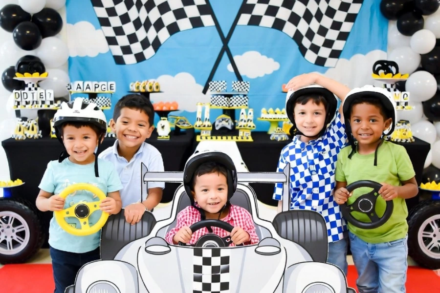 cars birthday party photo booth with cardboard race car backdrop