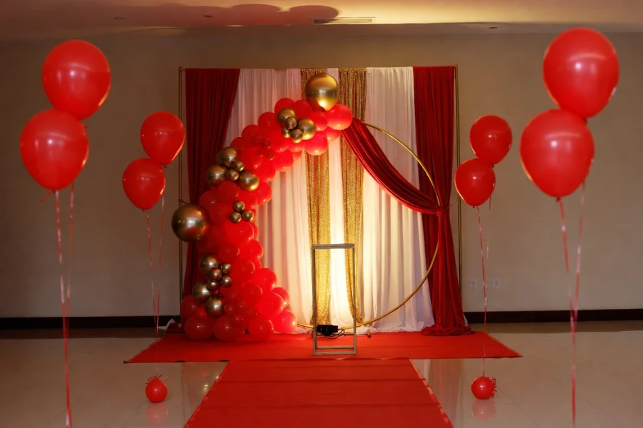 red luxury birthday party decorations with balloon arch red carpet and gold accents